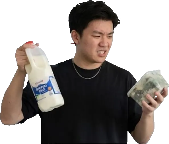 Person holding expired milk and vegetables